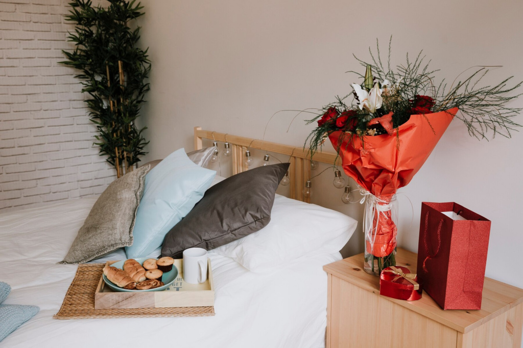 bouquet-and-presents-near-bed-with-breakfast_23-2147742135.jpg